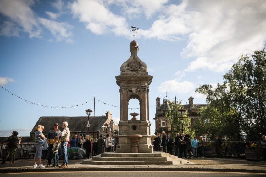 Murray fountain in Crieff Square with gathering of people around it