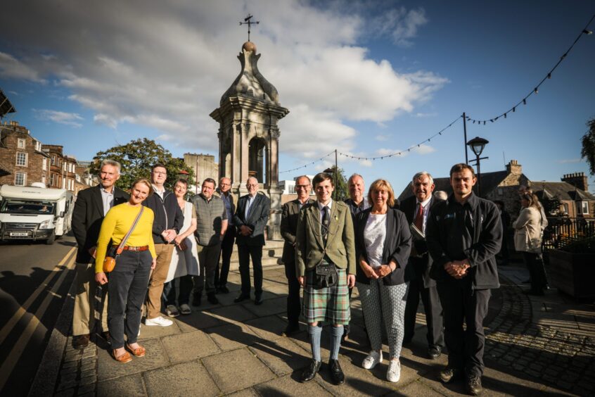 Group of people standing in front of fountain in Crieff