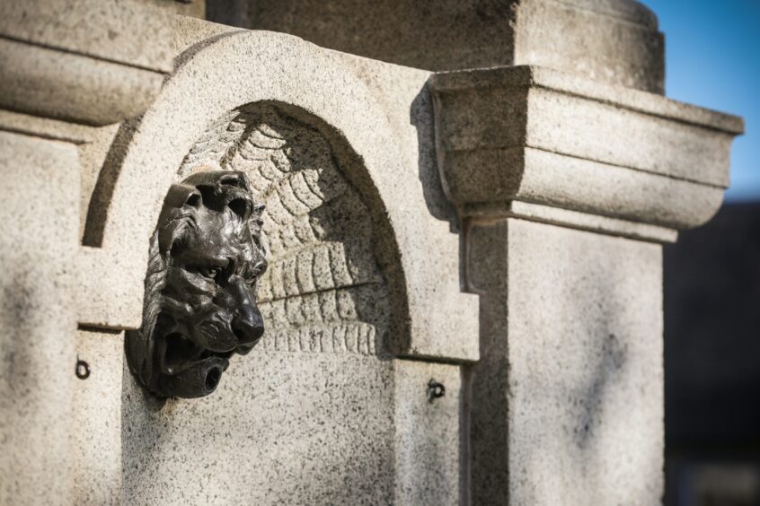 Close up of bronze lion head on Crieff fountain