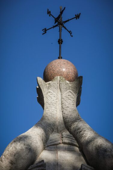 Top of Crieff fountain featuring brass weathervane on top of granite fish tails