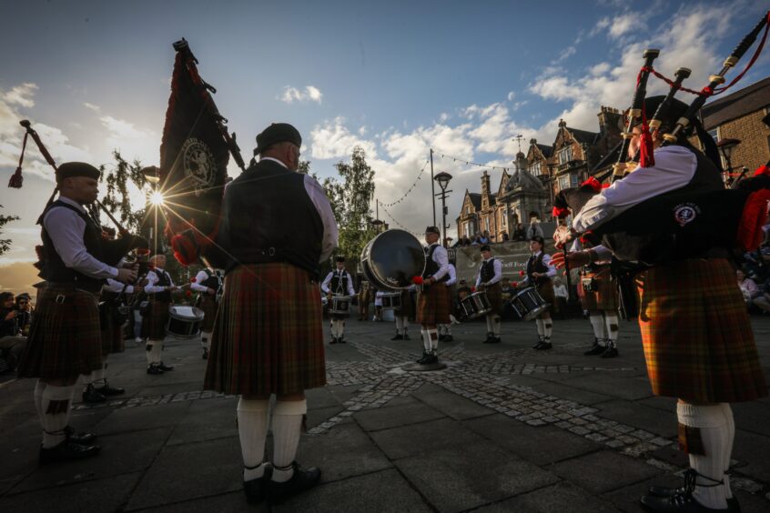 Sun going down as pipe band plays in Crieff town square