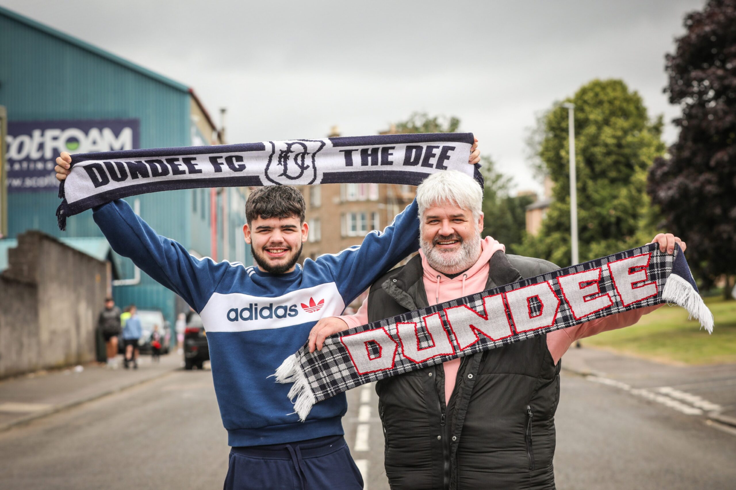 Father and son Thomas and Steven Walker holding Dundee scarfs.