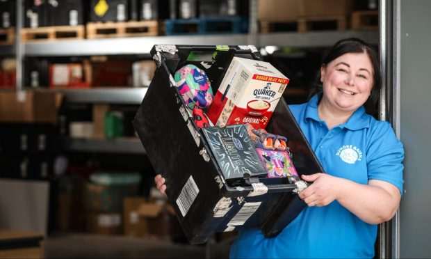 Food bank manager Genna Millar in the warehouse with one of her packages.