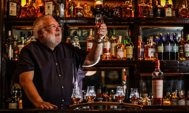 John Justice raising a glass in The Whisky Saloon. Image: Mhairi Edwards/DC Thomson