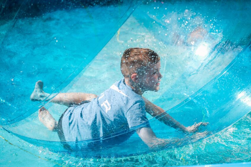 Theo Grant, 6, has fun in the water walking ride at St Andrews Lammas Market