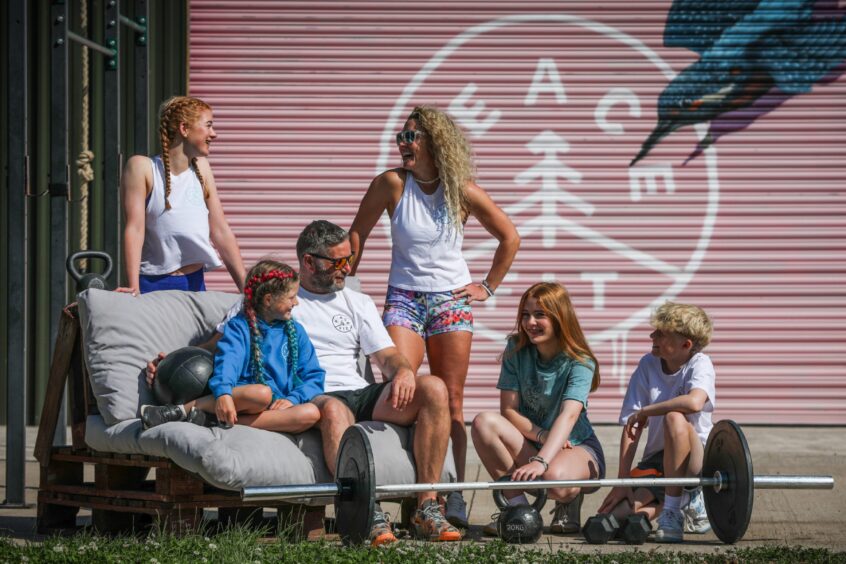 Emma and her husband and children beside the Peacefit gym