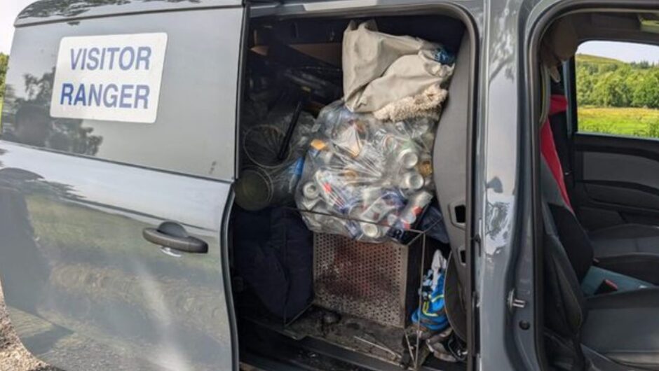 Visitor ranger van with bags of rubbish spilling out