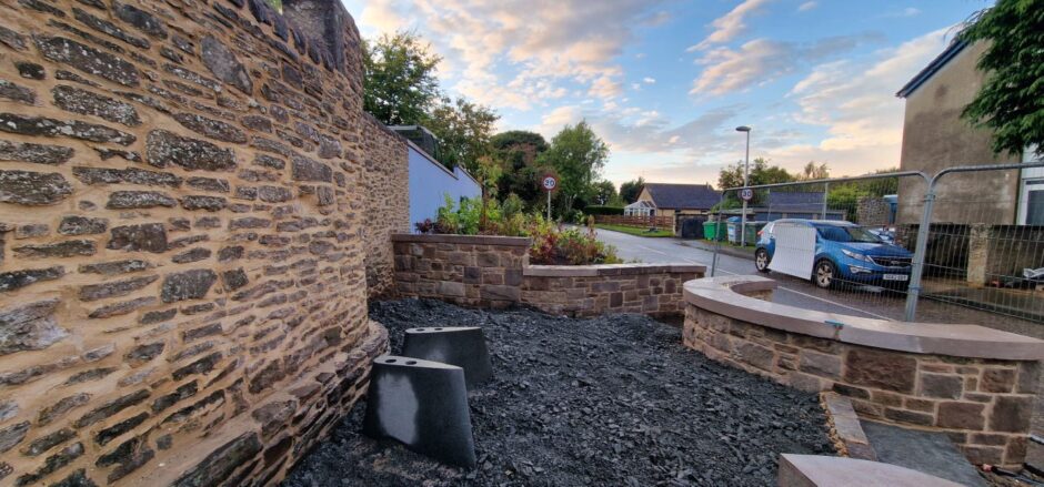 Sandy Gunn garden under constriction, with seated area for bench and plants and trees beyond