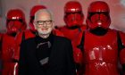 Star Wars actor Ian McDiarmid beside a row of red-armoured Storm Troops