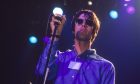 Oasis frontman Liam Gallagher holds the mic while on stage in 1994, the year Definitely Maybe was released