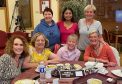 group of seven women around lunch table