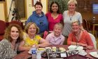 group of seven women around lunch table