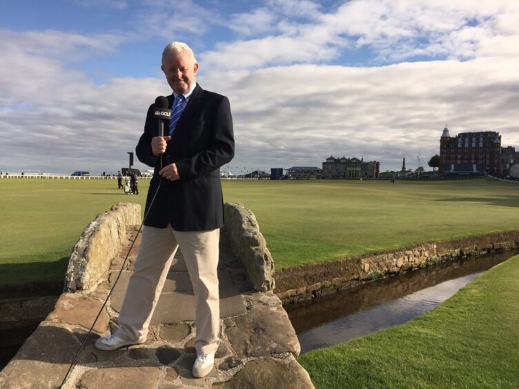 Dougie Donnelly stands on the Swilcan Bridge at St Andrews with microphone in hand, ready to broadcast from the Home of Golf