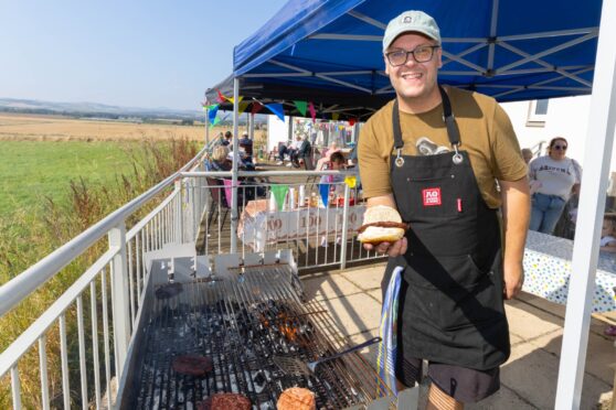 John Wilkin mans the BBQ at the Eassie Hall 100th birthday party. Image: Paul Reid