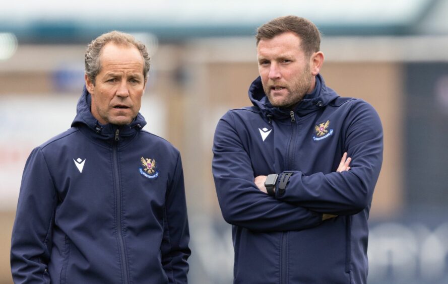 Coaches Andy Kirk and Alex Cleland talking while standing side by side and wearing St Johnstone training jackets