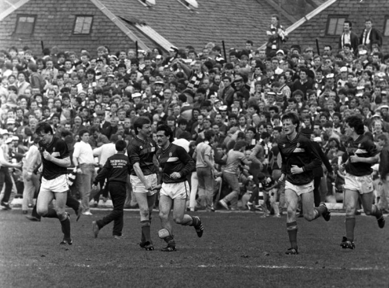 The Hearts fans look on stunned as Albert Kidd celebrates his strike for Dundee FC