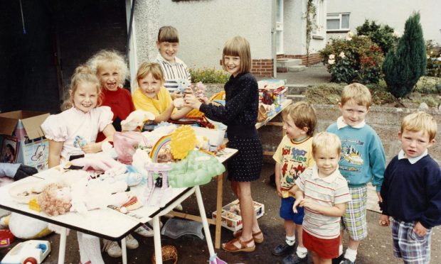 youngsters around a table at a charity garage sale