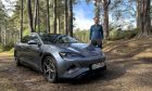 Jack McKeown and the BYD Seal in the Highlands, surrounded by trees.