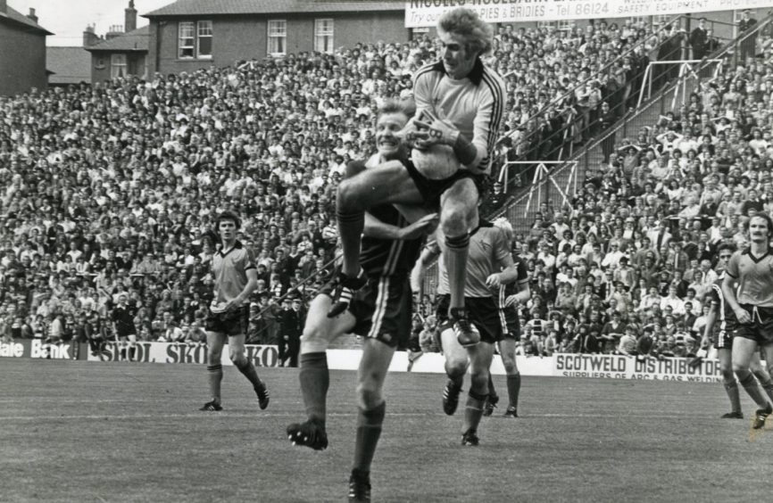 Dundee United goalie Peter Bonetti catches the ball while being challenged