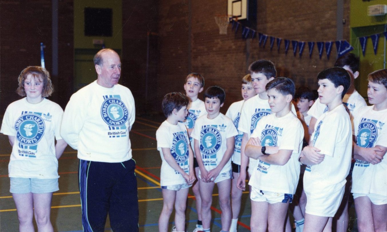 Sir Bobby speaks to youngsters in a gym at Grove Academy in January 1991.