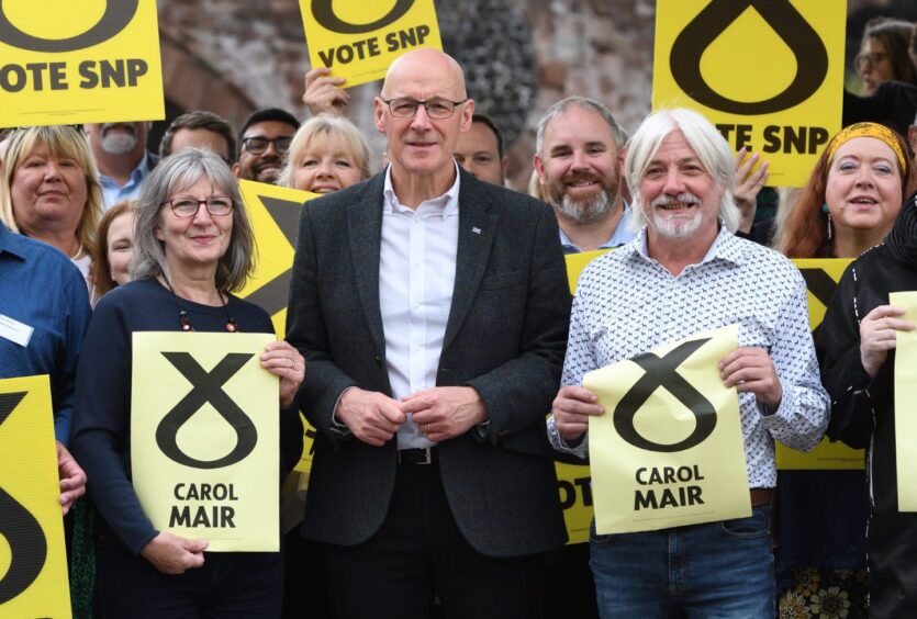 John Swinney with Perth and Kinross council leader Grant Laing and new Perth City North councillor Carol Mair surrounded by activists holding yellow SNP posters