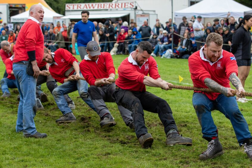 A team pull hard during the tug o war at Pitlochry Highland Games 