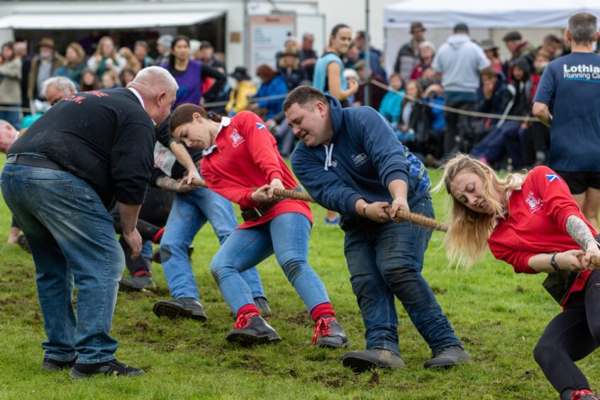 A team receive some coaching and encouragement during the tug o' war. 