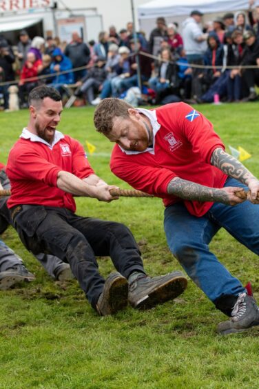 Men dig their heels in during the tug o'war at Pitlochry Highland Games.