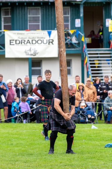 Crowds look on as the caber is tossed. 