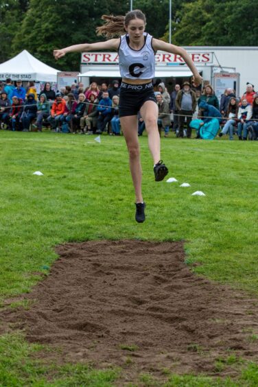 A girl jumps in the track and field events. 