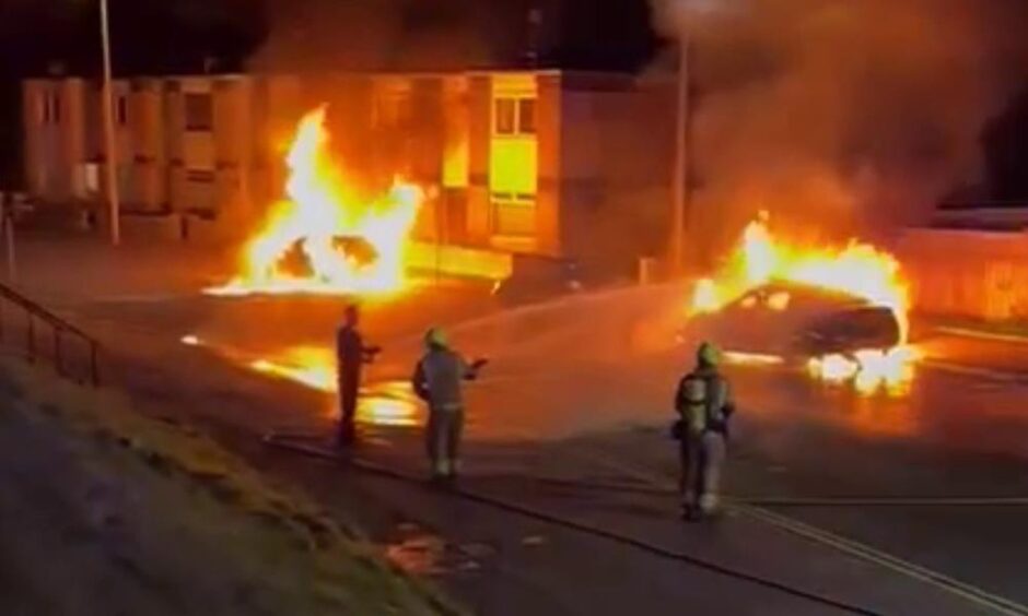 Firefighters extinguish the car fires on Charleston Drive 