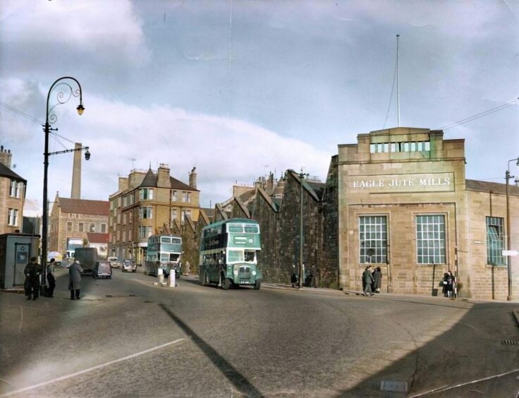 A green bus going to the city centre in 1961 and passing the Eagle jute mill