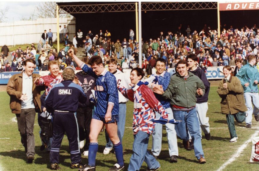 Cowdenbeath FC players and fans on the pitch celebrating in 1992.