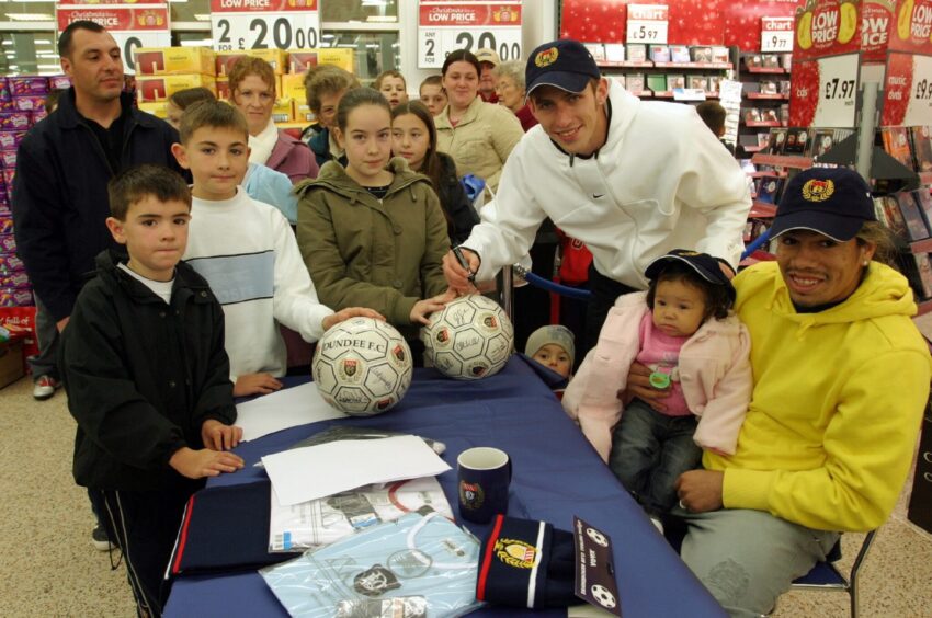 Fans surround a table to meet Fabian Caballero, who brought his daughter to a signing session at Asda Kirkton.