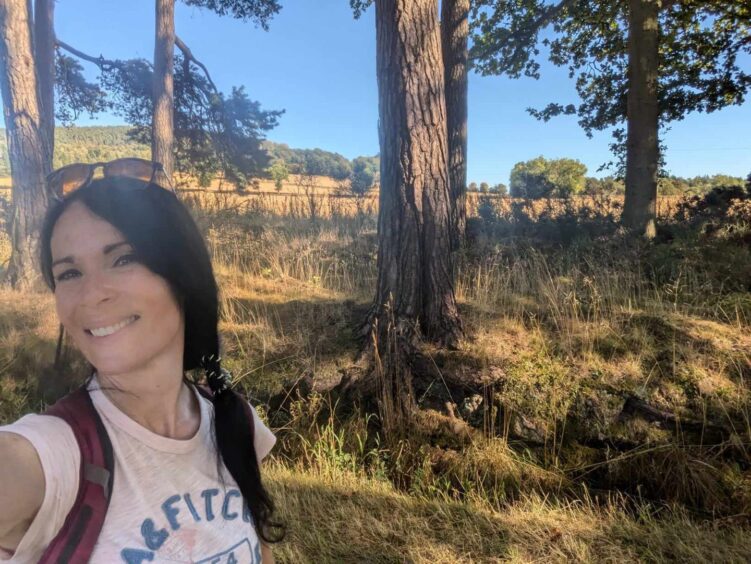 Gayle strolls along a woodland path en-route to the summit of Fothringham Hill. Image: Gayle Ritchie.