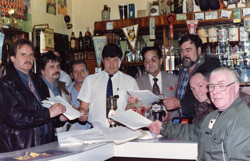 Gordon Bruce, mine host, and regulars with the petition. 