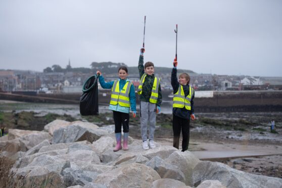 Litter pickers at the ready for Ladyloan pupils (from left) Cara Gillespie, Mason Millar and Ethen Mackie. Image: Kim Cessford / DC Thomson