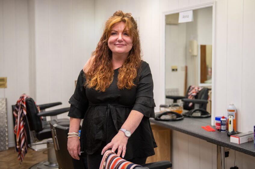 Samantha Cuthbert leaning on chair in barber shop