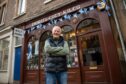 David Gill, arms folded outside his Perth City Kilts shop