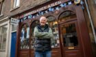 David Gill, arms folded outside his Perth City Kilts shop