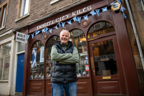 David Gill, arms folded outside his Perth City Kilts shop