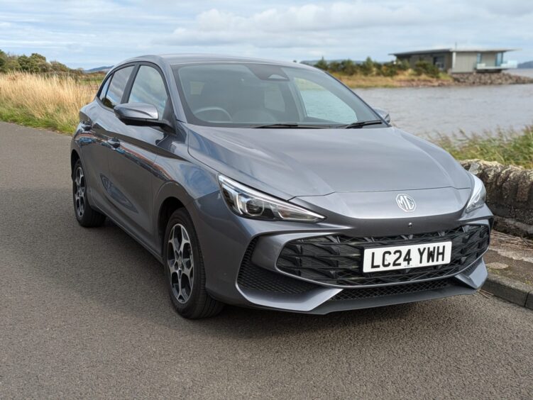  the MG3 Hybrid on the road with a loch in the background