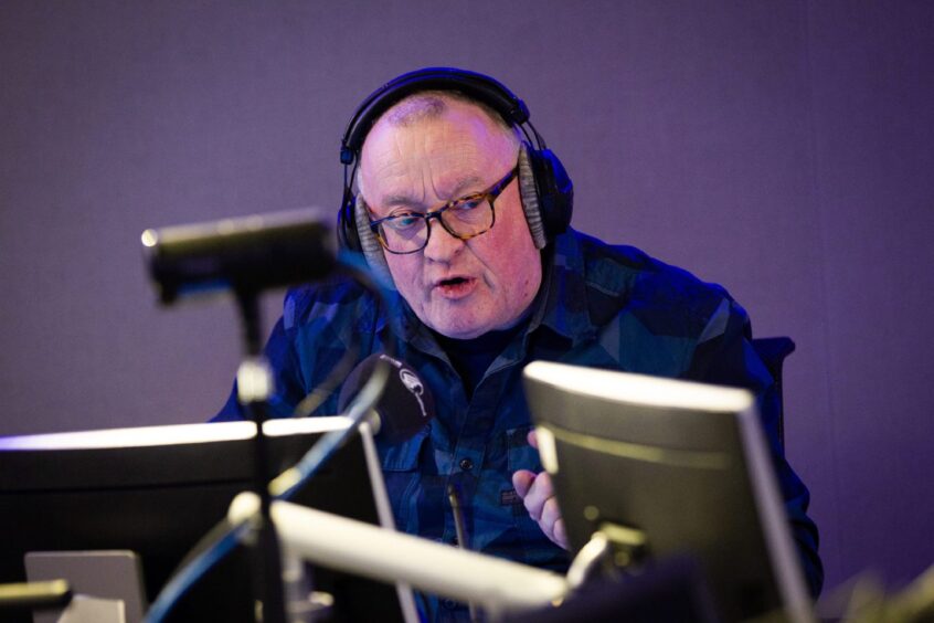 Broadcaster Stuart Cosgrove with headphones on in a studio