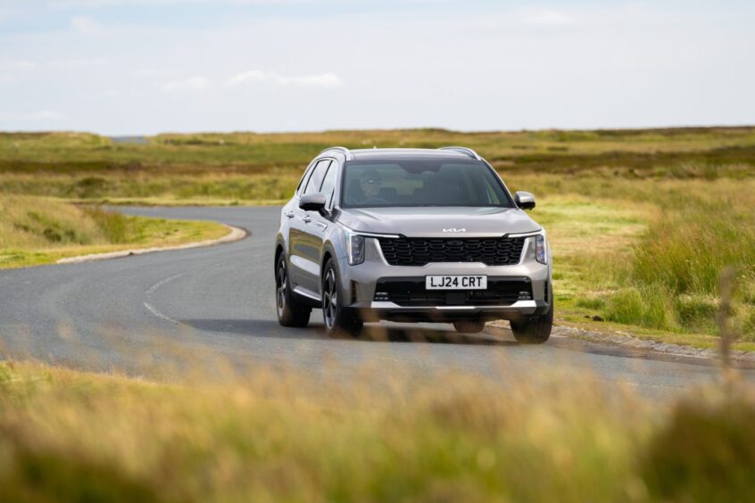 the car seen from the front on a winding road through fields