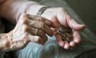 Old woman holding coins