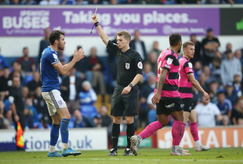 Scott Fraser's time in the blue of Ipswich did not go to plan. He is pictured getting a yellow card from the referee