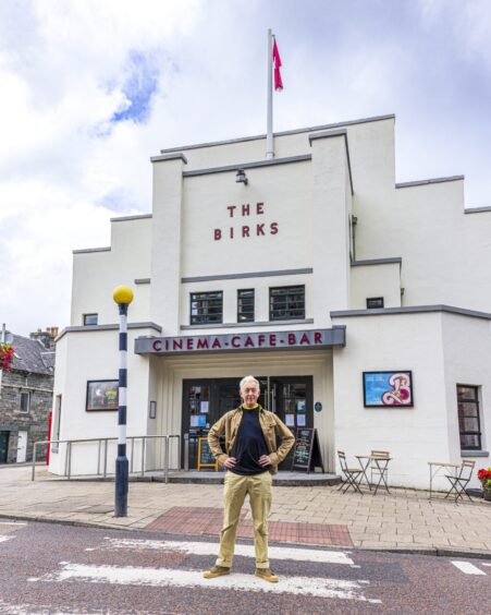 Alan Cumming standing outside The Birks cinema in the centre of Aberfeldy