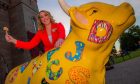 Hayley Smith standing next to yellow painted cow sculpture outside Scone Palace