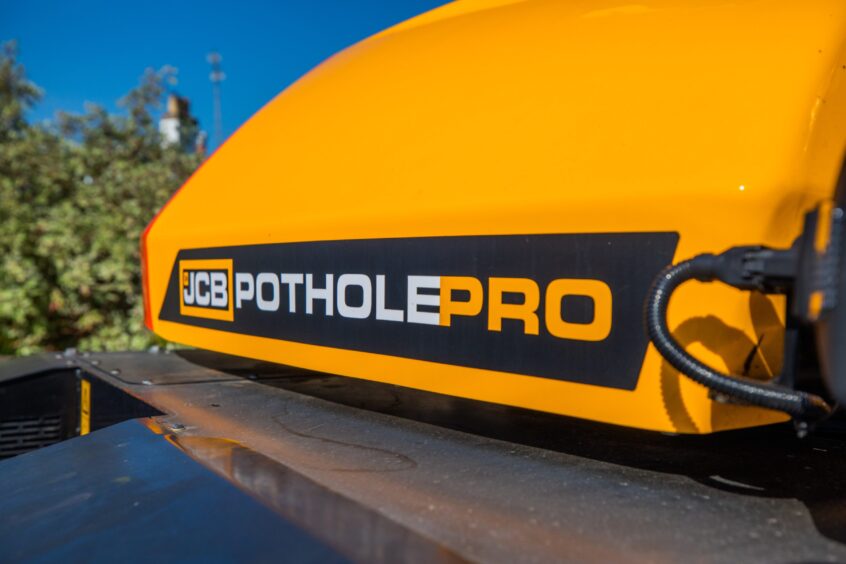 Close-up of logo for JCB Pothole pro machine on orange livery