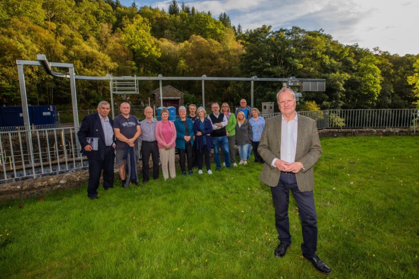 Pete Wishart standing in front of St Fillans residents beside structure